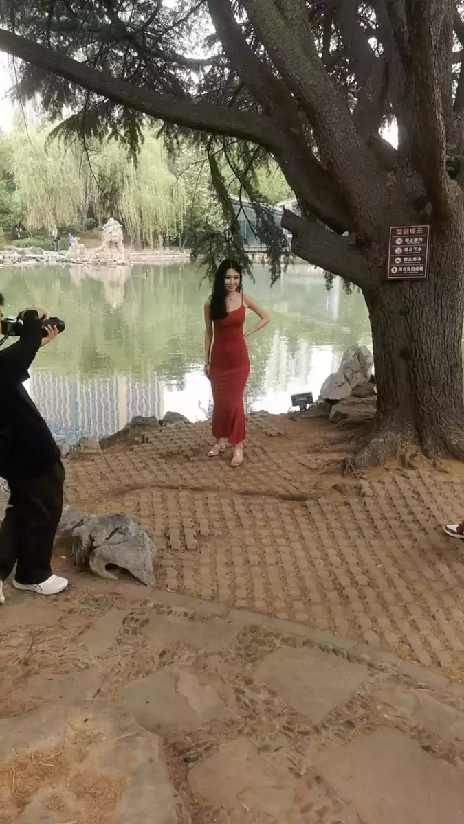公园里拍照的修长的红色女子 当天